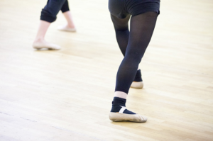 Promotional image for Contemporary Ballet. Picture of a pair of child's legs wearing black tights and ballet pumps.